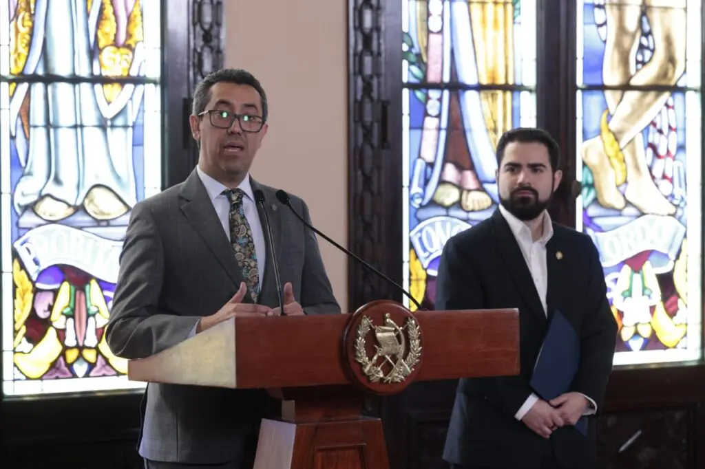 Jonathan Menkos y Santiago Palomo, ministro de Finanzas y secretario de Comunicación, respectivamente, durante la conferencia ofrecida el 28 de noviembre de 2024.