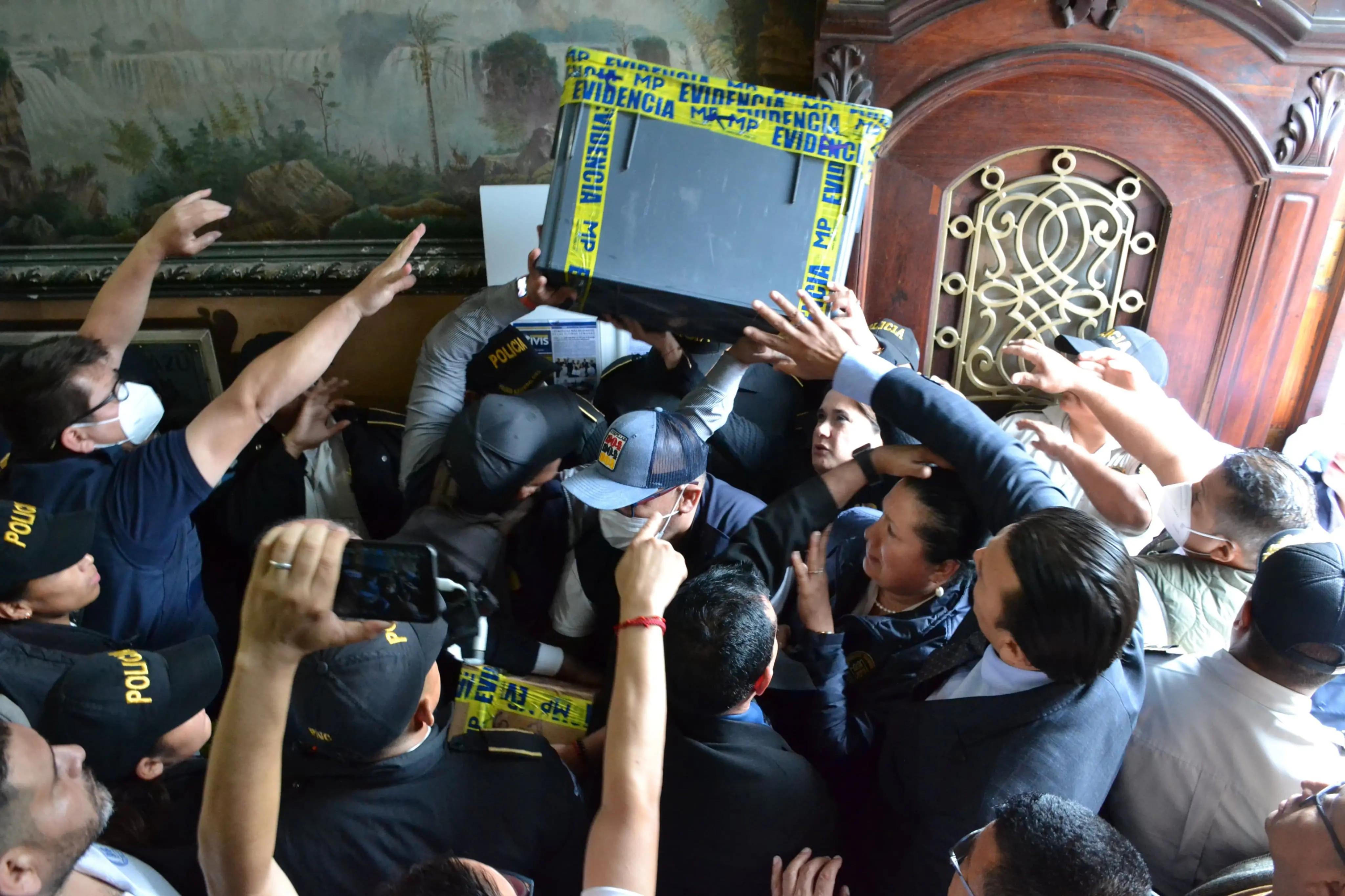 La magistrada Blanca Alfaro rodeada de agentes de policía, funcionarios del Ministerio Público y empleados del TSE, durante el forcejeo que rodeó al proceso de allanamiento del Tribunal en octubre de 2023. Foto: Tribunal Supremo Electoral.